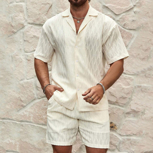 Mann in weißem Leinenhemd und Shorts vor Steinwand. Sommermode, Herrenbekleidung, lässiger Stil, Leinenoutfit, Kurzarmhemd.