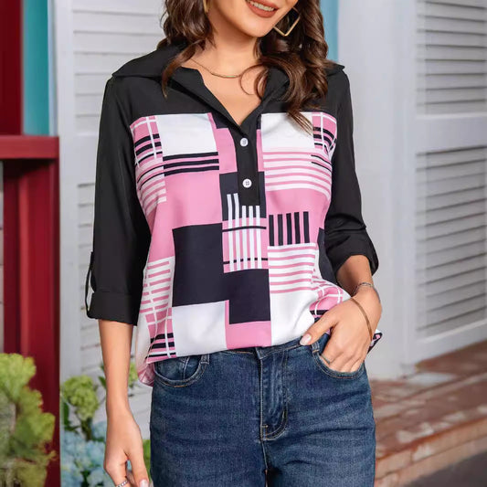 Frau trägt modische Bluse mit geometrischem Muster in Rosa, Schwarz und Weiß, kombiniert mit blauen Jeans. Trendige Damenmode, Freizeitlook.