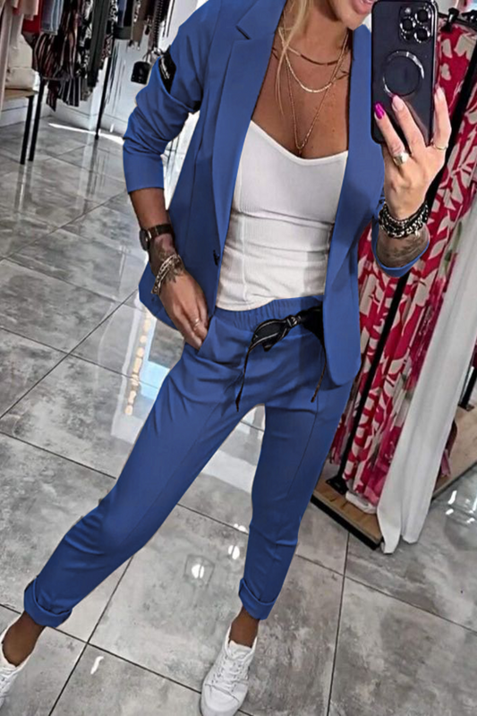 Frau im blauen Anzug mit weißem Top, macht Selfie in Boutique. Modetrend, Damenmode, eleganter Freizeitlook, stilvolle Kleidung.