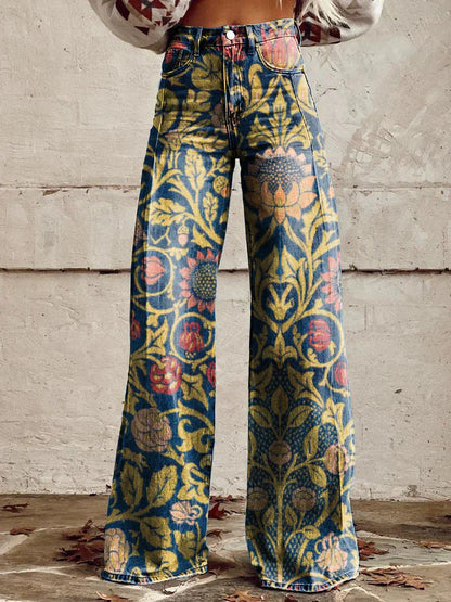 Frau trägt weite Jeans mit floralem Vintage-Muster, gelb-blau-rot, vor rustikaler Wand. Modetrend, Retro-Design, Damenmode.