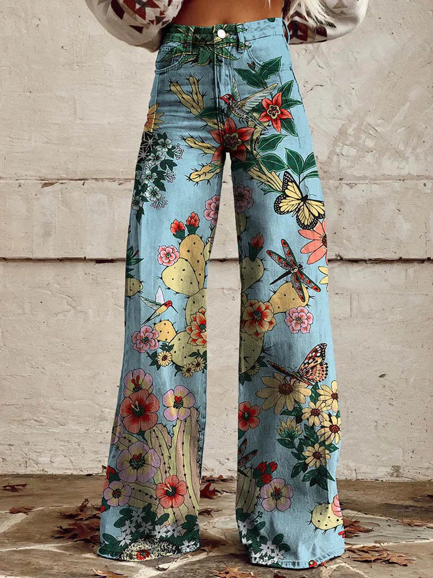 Frau trägt weite Jeans mit buntem Blumen- und Schmetterlingsmuster, ideal für Boho-Mode. Perfekt für trendige, sommerliche Outfits.