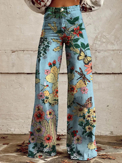 Frau trägt weite Jeans mit buntem Blumen- und Schmetterlingsmuster, ideal für Boho-Mode. Perfekt für trendige, sommerliche Outfits.