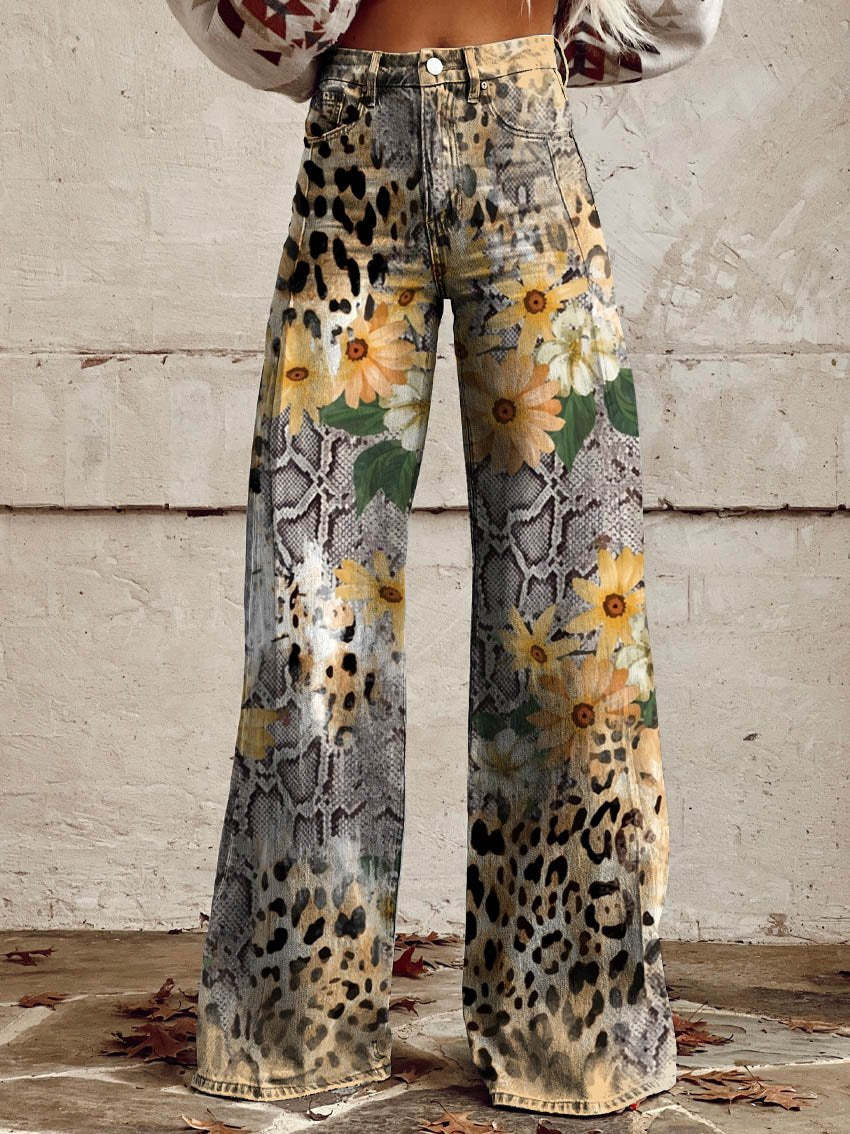 Frau trägt weite Hose mit Leoparden- und Schlangenprint, verziert mit gelben Blumen, vor weißer Wand. Modetrend, Damenmode, auffällige Muster.