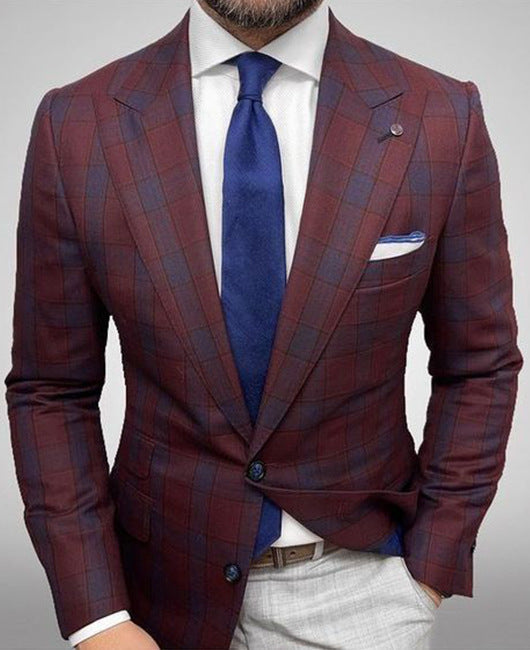 Mann im karierten, bordeauxfarbenen Anzug mit blauer Krawatte und weißem Hemd. Elegante Herrenmode, stilvoller Business-Look.