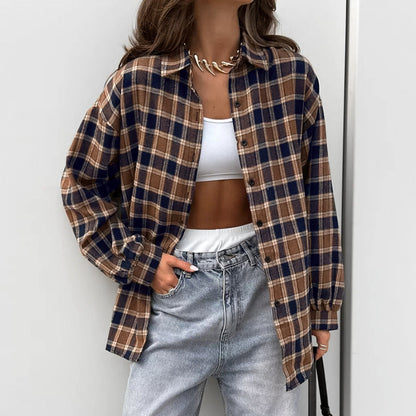 Frau trägt karierte Oversize-Hemdjacke, weißes Crop-Top und Jeans. Modetrend, lässiger Streetstyle, Herbstmode, Damenbekleidung.
