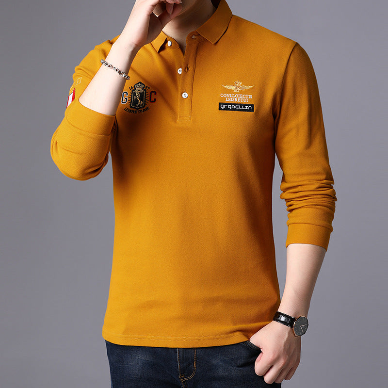 Gelbes Herren-Poloshirt mit langen Ärmeln, aufgestickten Logos und Abzeichen, kombiniert mit blauer Jeans. Modisches Freizeitoutfit für Männer.
