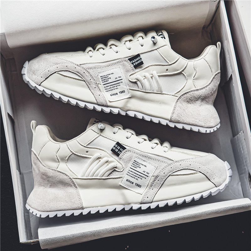 Weiße Sneaker in einem Karton, modernes Design mit Wildleder- und Mesh-Elementen, seitlicher Textaufdruck, trendige Sportschuhe für Herren.