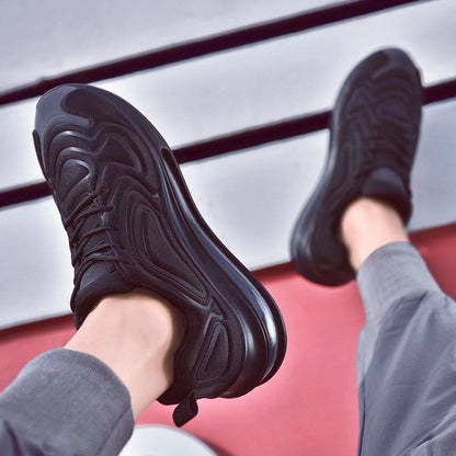 Schwarze Sneaker auf rotem Hintergrund, moderne Sportschuhe, stilvolles Design, bequeme Laufschuhe, trendige Herrenmode, Freizeitkleidung.