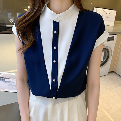 Damenbluse in Blau-Weiß mit Perlenknöpfen, elegantes Design, ärmellos, modisch, ideal für Büro oder Freizeit. Im Hintergrund Waschmaschine und Einkaufstasche.