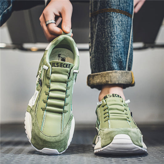 Grüne Sneaker mit weißer Sohle, getragen von Person in hochgekrempelten Jeans. Modische Freizeitschuhe, urbaner Stil, Nahaufnahme.