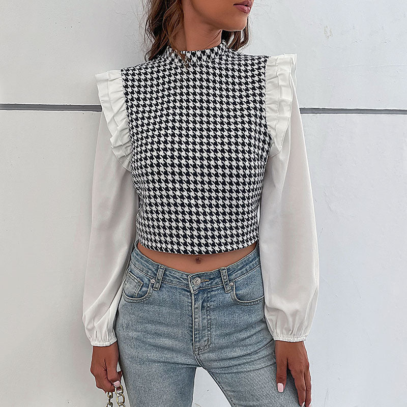 Frau trägt schwarz-weiß kariertes Oberteil mit Rüschen und weiße Ärmel, kombiniert mit blauen Jeans. Modetrend, stilvolles Outfit, Streetwear.