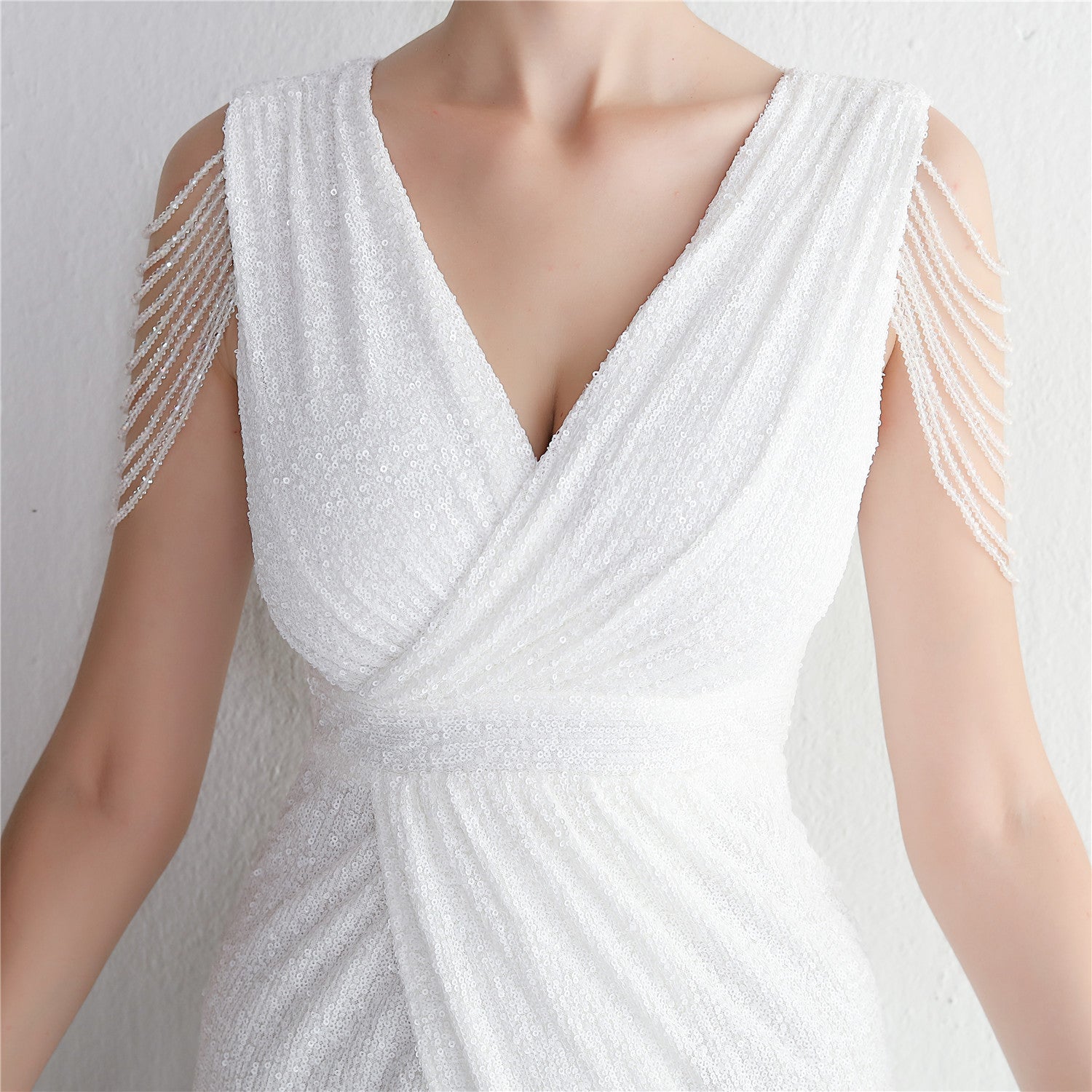 Weiße, ärmellose Abendkleid mit V-Ausschnitt und Perlenverzierungen an den Schultern, elegantes Design, ideal für formelle Anlässe.