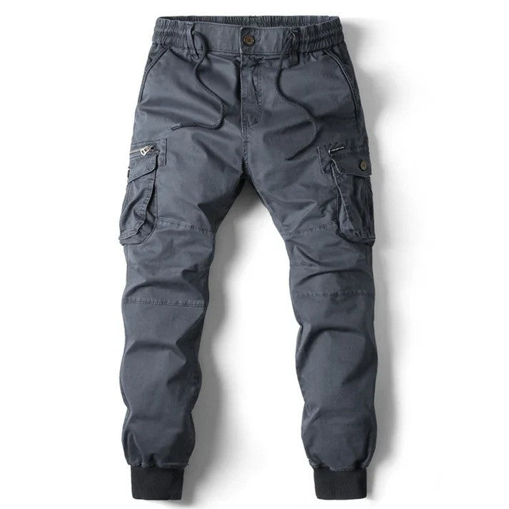 Graue Cargohose für Herren mit elastischem Bund, mehreren Taschen und Knopfverschluss. Ideal für Outdoor-Aktivitäten und Freizeitkleidung.