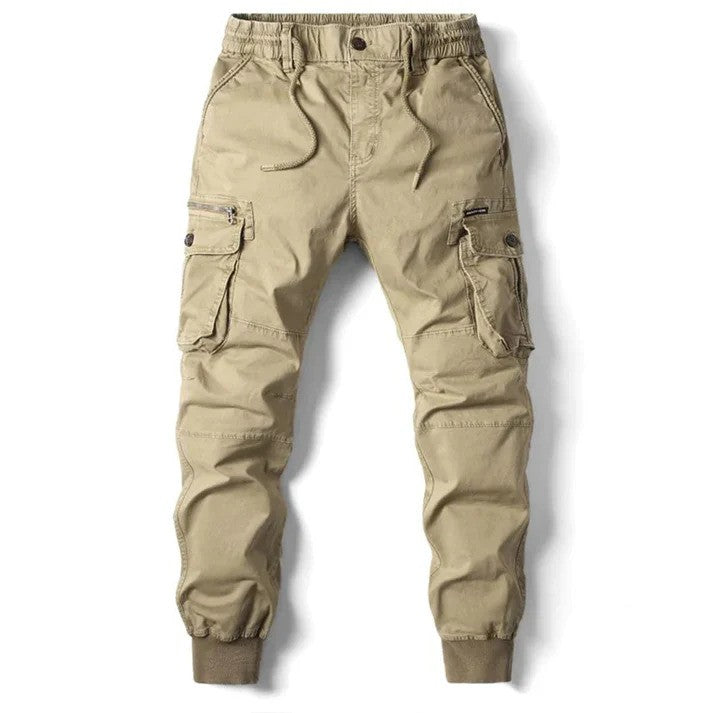 Beige Cargo-Hose für Herren mit elastischem Bund, mehreren Taschen und Knopfverschluss. Ideal für Outdoor-Aktivitäten und Freizeitkleidung.