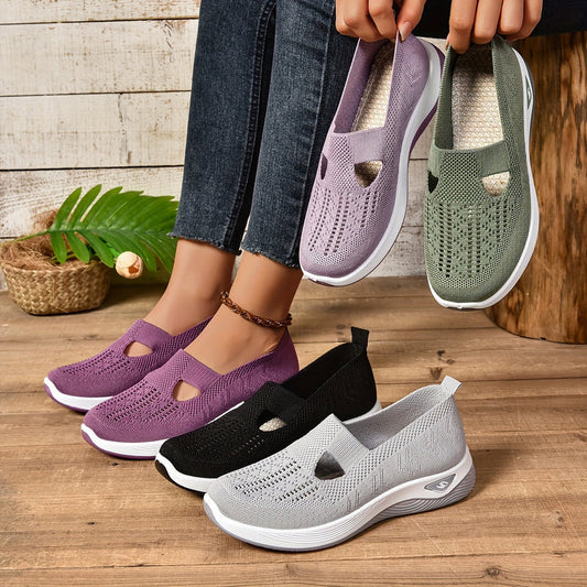 Damen Sneaker in Lila, Schwarz, Grau und Grün auf Holzboden. Bequeme, atmungsaktive Strickschuhe mit weißer Sohle. Ideal für Freizeit und Alltag.