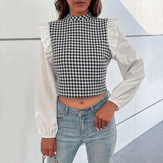 Frau trägt schwarz-weiß kariertes Oberteil mit Rüschenärmeln und Jeans. Modetrend, elegantes Design, Streetstyle, Herbstmode.