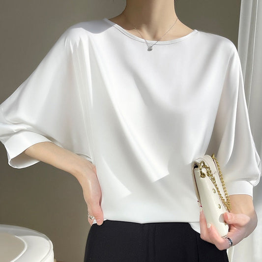 Weiße Seidenbluse Damen, elegant und stilvoll, kombiniert mit schwarzer Hose und weißer Handtasche. Perfekt für Business- und Freizeitmode.