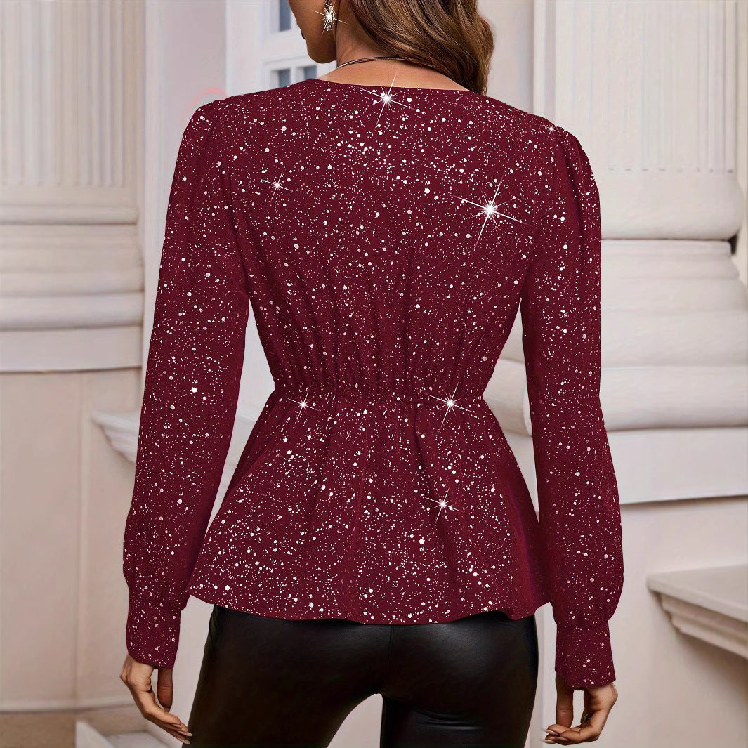 Frau in glitzernder, roter Bluse mit langen Ärmeln und schwarzer Lederhose, steht vor klassischer Architektur. Elegante Abendmode, glamouröser Look.