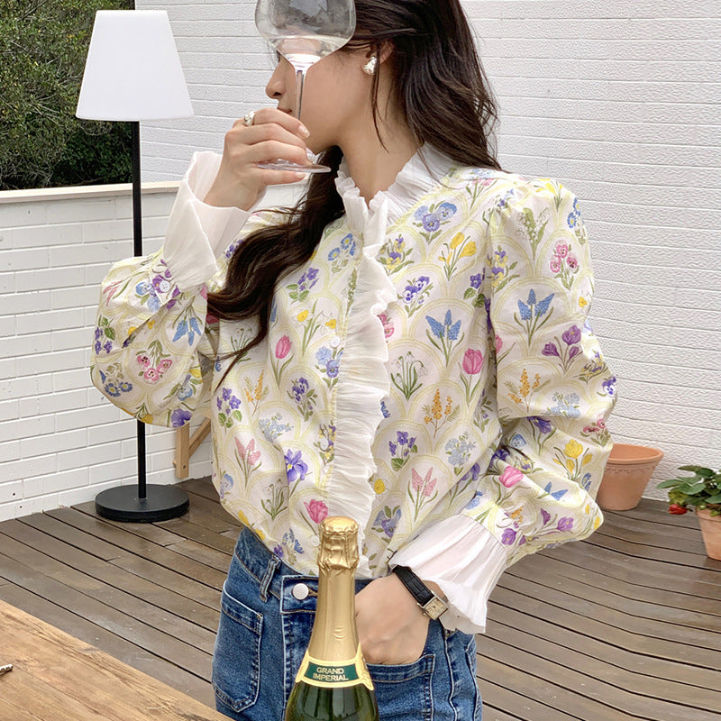 Frau in geblümter Bluse mit Sektflasche auf Terrasse. Stilvolle Mode, Freizeitkleidung, Outdoor-Event, Frühlingslook.