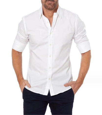 Mann in weißem Hemd mit hochgekrempelten Ärmeln, Hände in Hosentaschen. Elegante Herrenmode, klassischer Look, Freizeitkleidung.