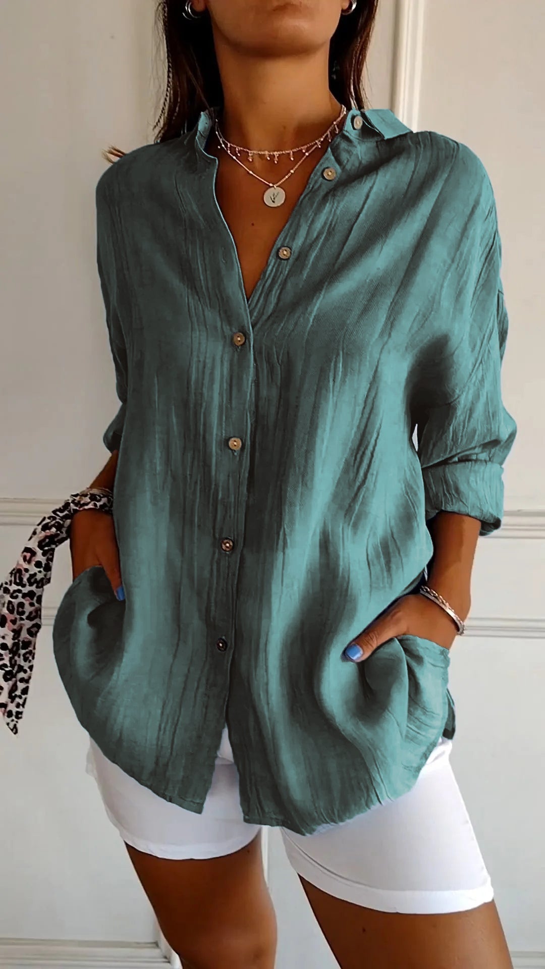 Frau in türkisfarbener Leinenbluse mit Knopfleiste und weißen Hosen, modisches Outfit, lässiger Stil, Sommermode, Accessoires, elegante Kleidung.