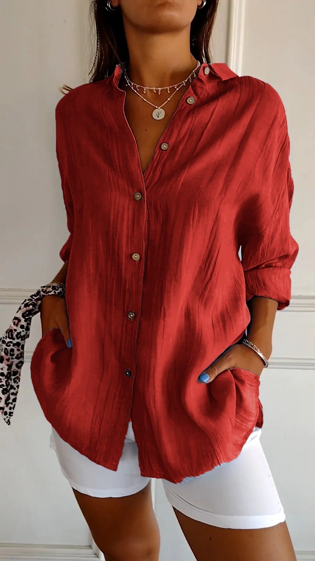 Frau in roter Bluse mit Knopfleiste und weißen Hosen, modisches Outfit, lässiger Stil, elegante Damenmode, trendige Kleidung.