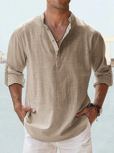 Mann in beigem Leinenhemd mit Stehkragen und hochgekrempelten Ärmeln, lässiger Sommerlook, ideal für Strandmode und Freizeitkleidung.